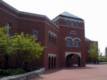 Exterior Linebaugh Library, a large brick building with two rows of windows and entryway. Bushes in the foreground